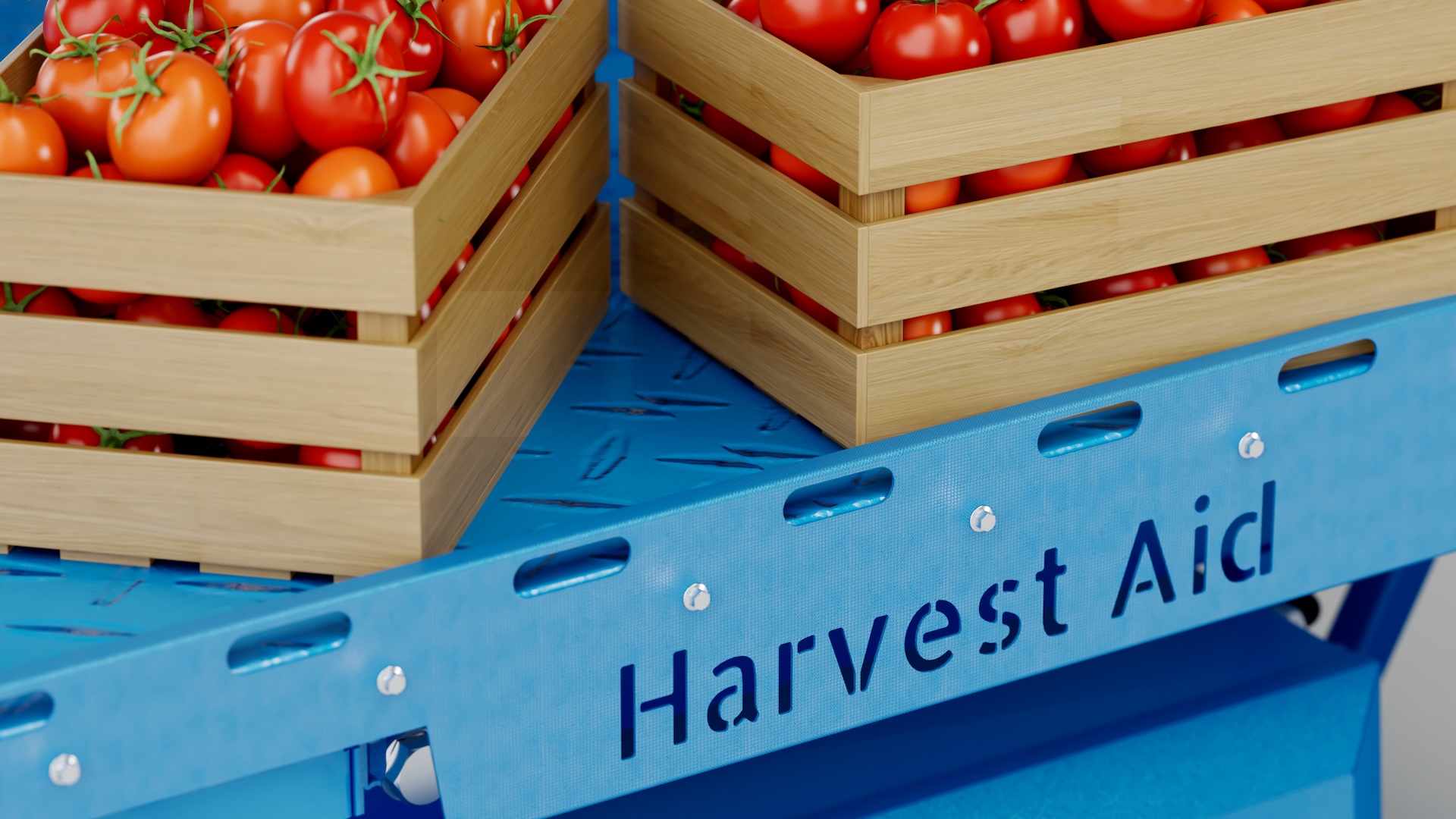 Two wooden crates of tomatoes on the FieldBot's blue chequer-plate deck, 'Harvest Aid' cut into the side rail