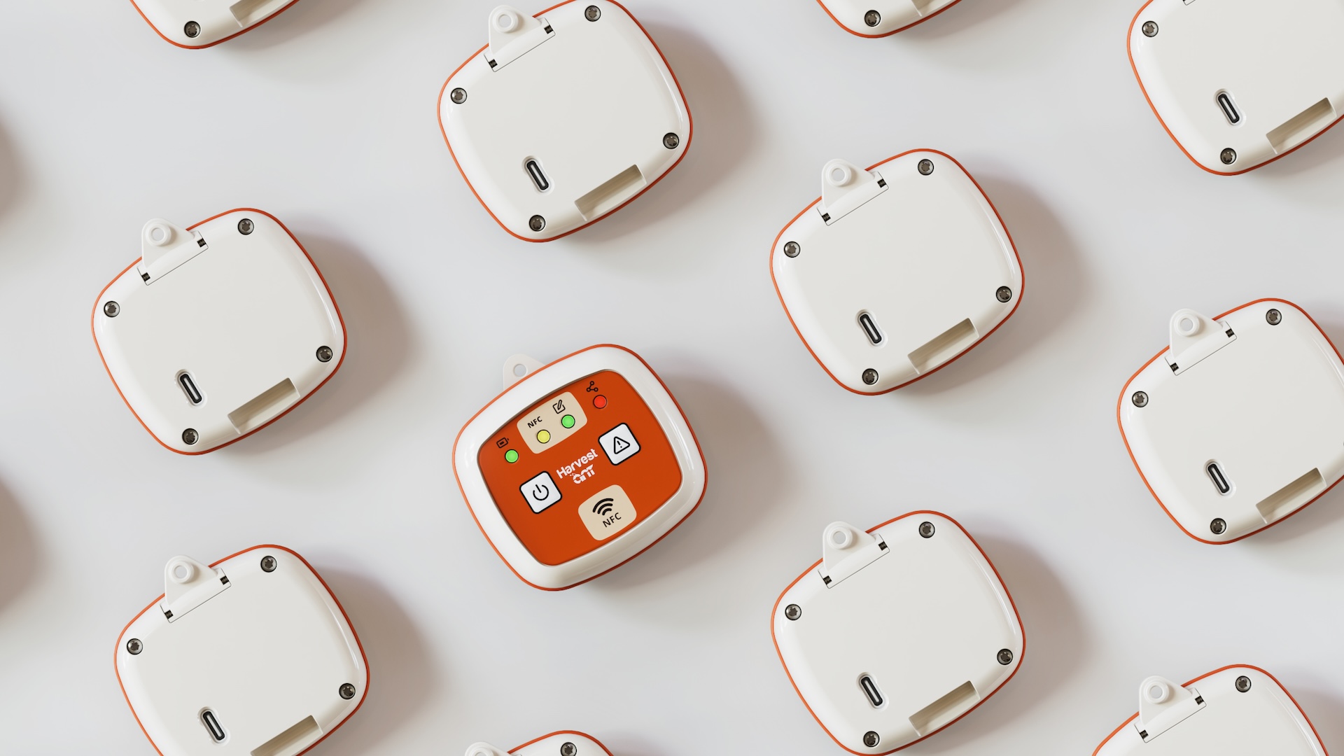 Rows of white wearable units face down, one flipped to show an orange faceplate with power button, status LEDs and NFC pad