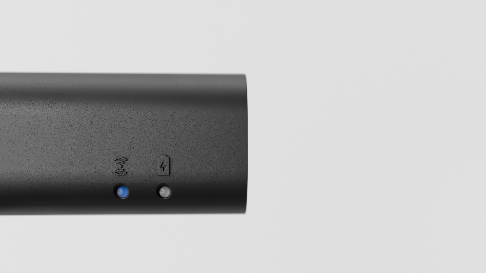 Close-up of the black cylindrical control unit, with embossed wireless and battery icons above a blue and a white LED