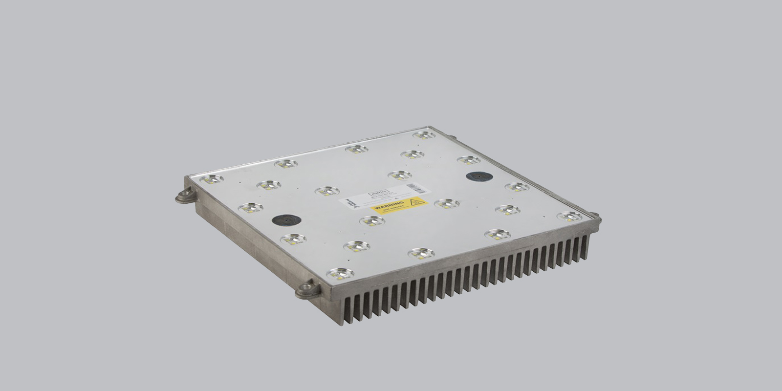 The Matrixx light engine at an angle, its LED array face labelled with a hot-surface warning and heatsink fins beneath